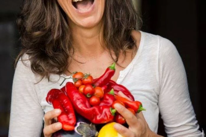 italian female chef with fresh vegetables laughing