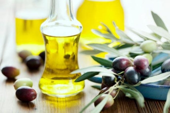 Extra virgin olive oil surrounded by Tuscan olives