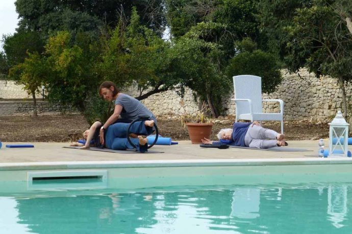 Pilates instructor helping students at the pool