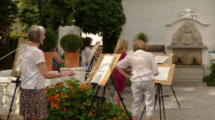 Group of mature women painting in a courtyard