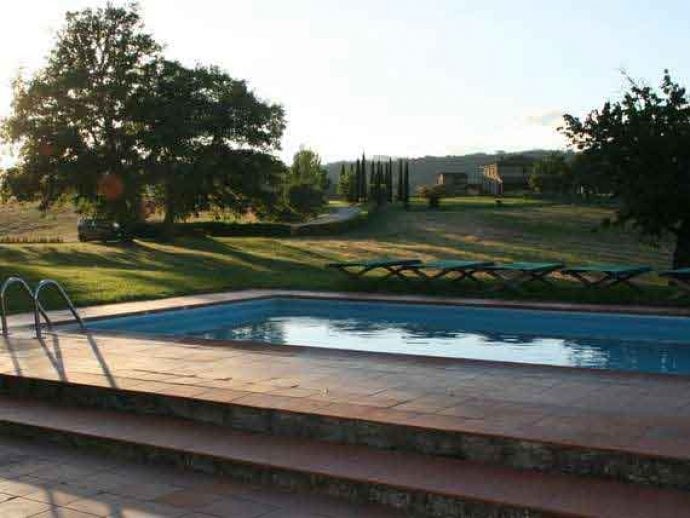 Sunny outdoor area and pool of villa Arezzo in Tuscany.