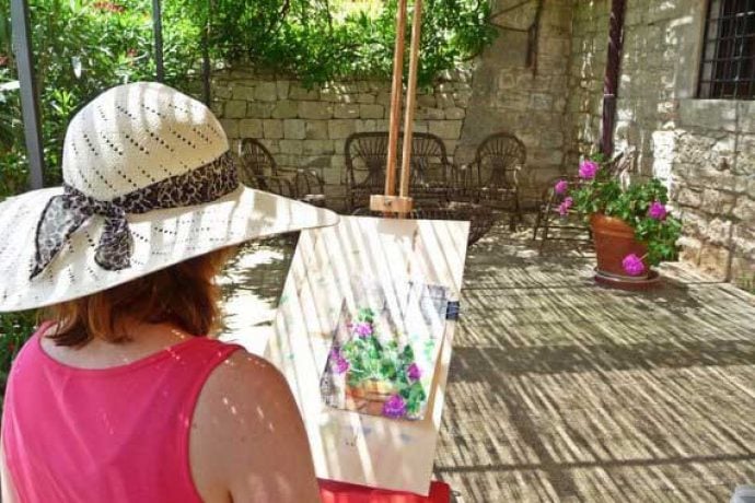 Art holiday guest painting on terrace.
