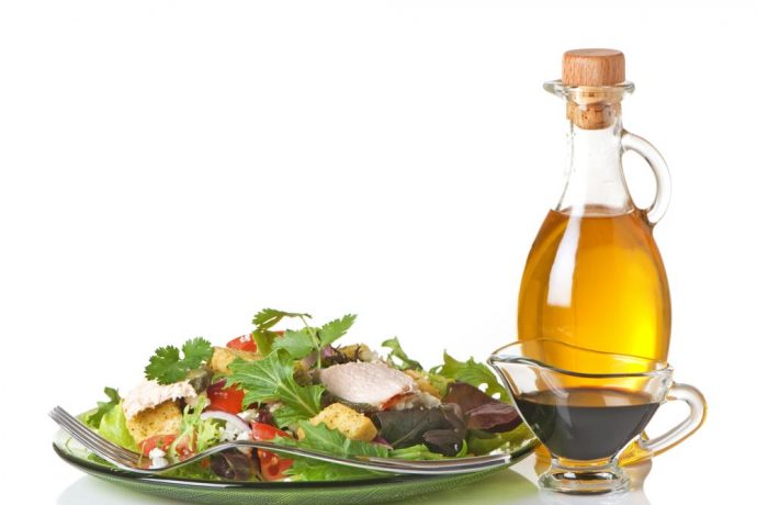 Deliciously fresh salad with a bottle of authentic Italian olive oil.