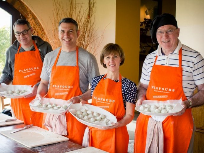 group of cooks showing pasta they have handmade