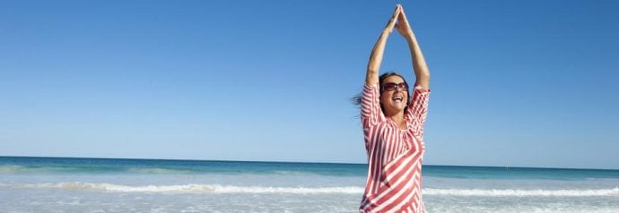 Happy women exercising on the beach under the blue sky