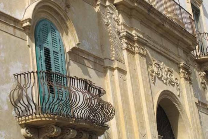 Impressive old stone building with a balcony in Sicily