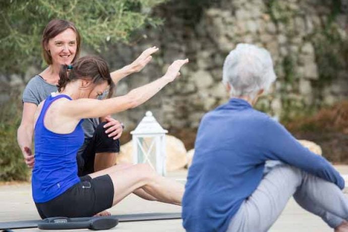 Instructor helping guests with Pilates pose