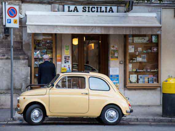 Small Italian car in front of house with Sicily sign. Small Italian car in front of house with Sicily sign.