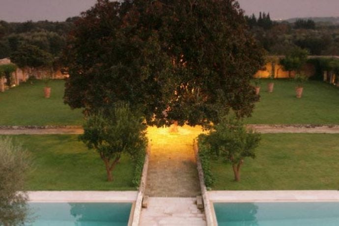 Pilates retreat venue at night time with view of garden and pool