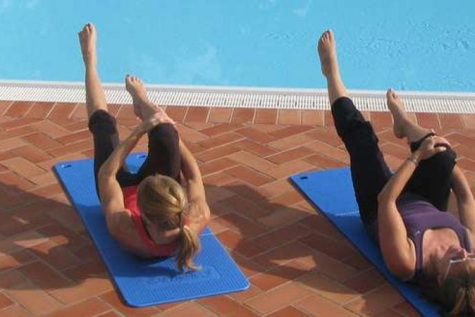 Pilates lessons by the pool at the holiday villa in Tuscany