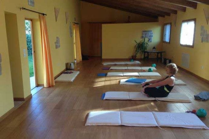 Pilates guest warming up in studio surrounded by mats