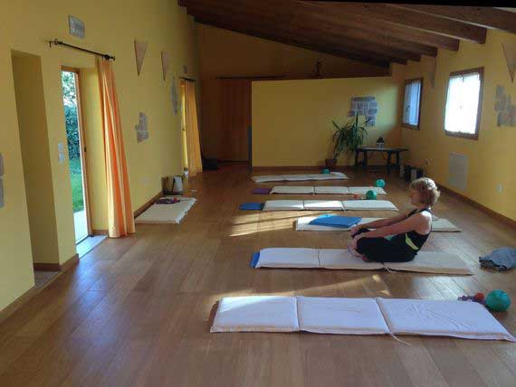 Pilates guest warming up in studio surrounded by mats