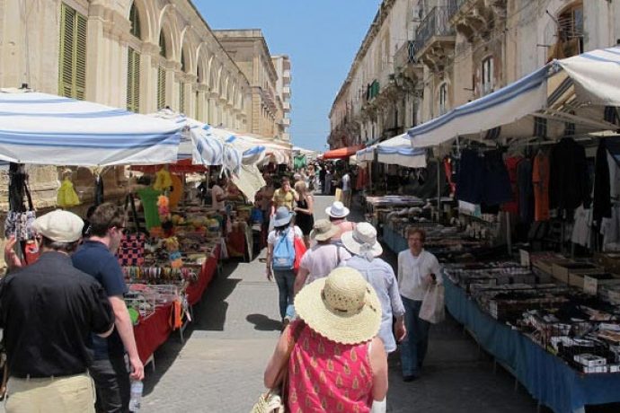 Guests visiting busy food market in Sicily.