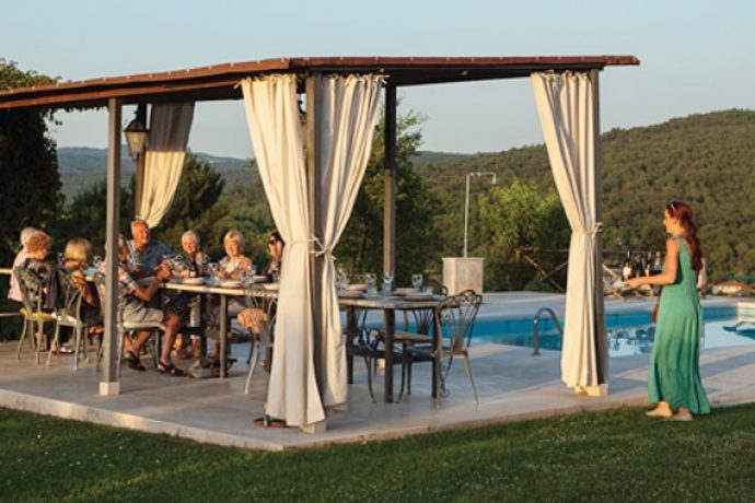 Group of cooking holiday guests and Flavours hostess serving them wine.