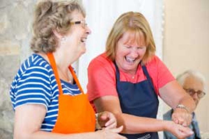 ladies cooking and laughing during italian cookery course
