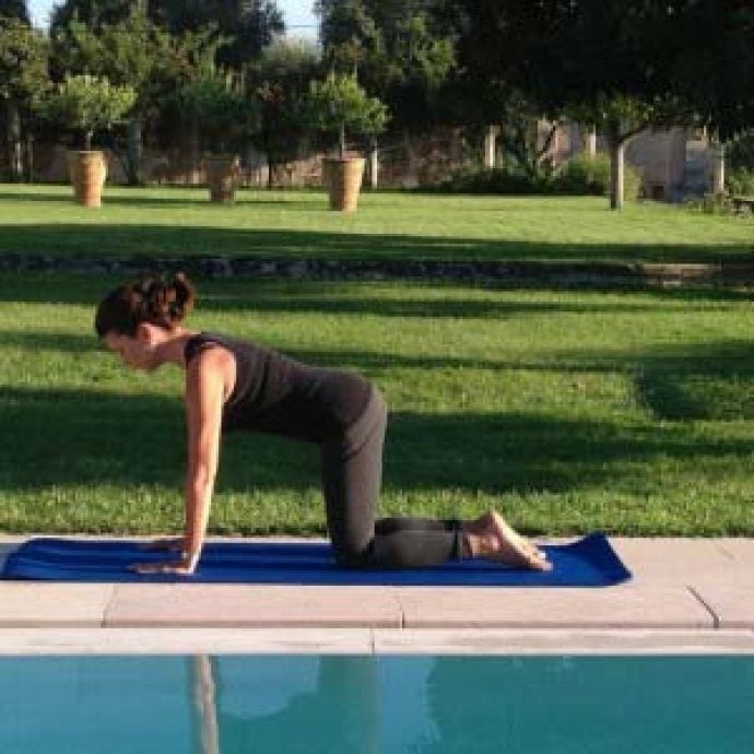 Woman doing Pilates pose at the swimming pool
