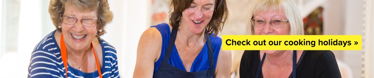 Three women laughing during a cooking holiday