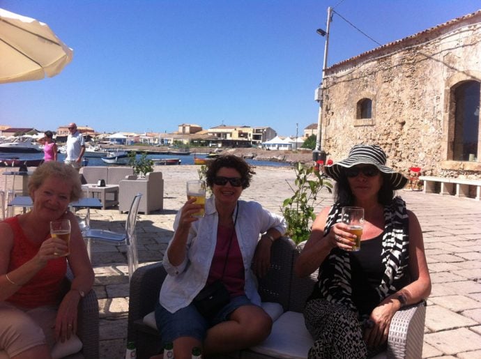 painting guests in sicily with drinks in sun