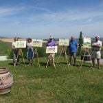 Group of students standing in Italian landscape next to easels and watercolour paintings