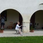 Woman with brush and easel sitting painting in watercolours