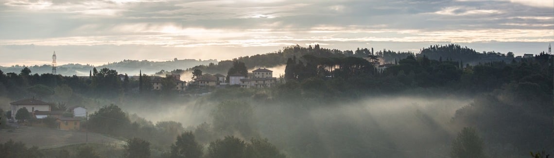 Tuscan village in morning fog