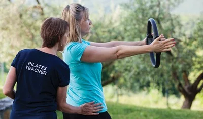 Pilates Teacher helping Flavours Holidays guest in Italian valley