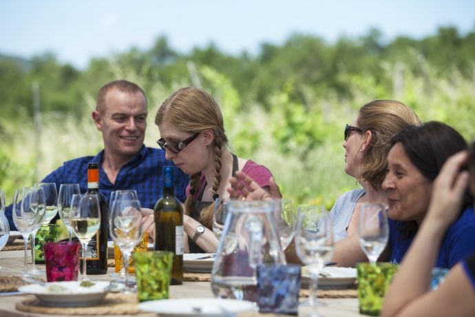 Single travellers getting together and chatting while enjoying an Italian meal