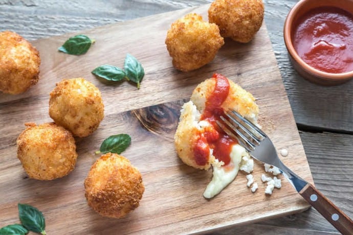Recipe to make crispy Arancini balls of deep fried rice filled with mozzarella.