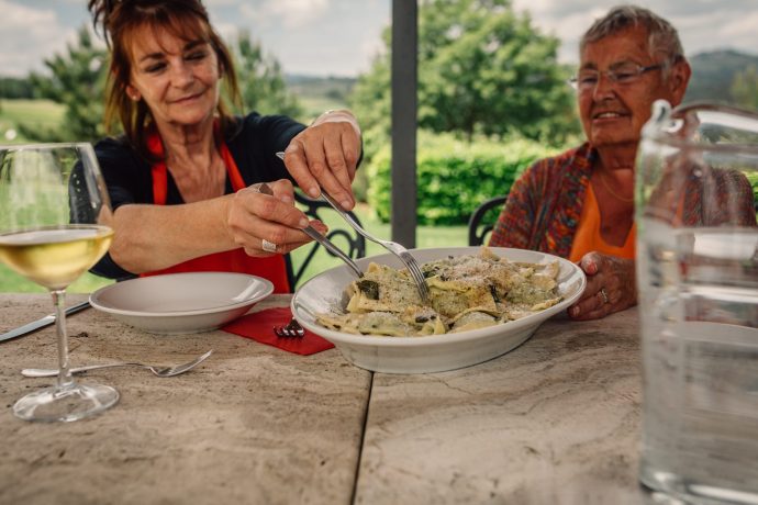 Two women sharing a dish of pasta