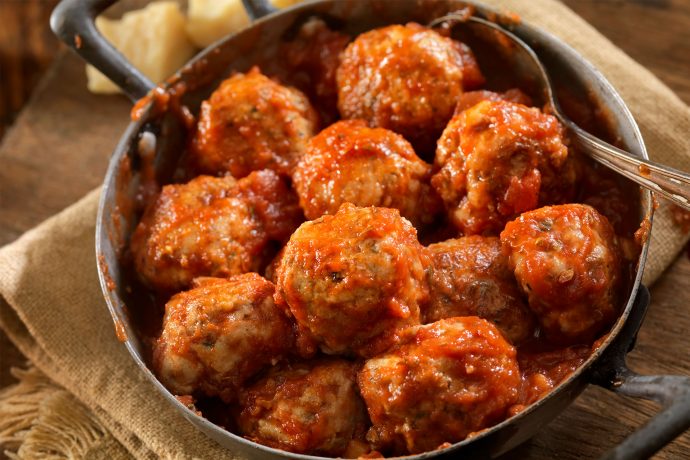 Italian meatballs being served in a pan