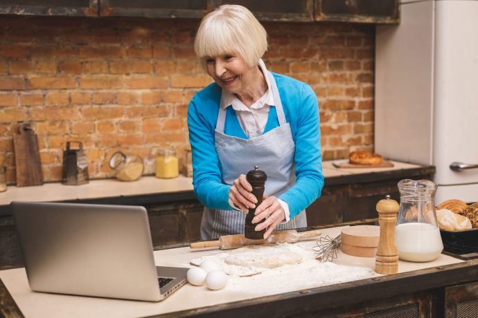 Woman cooking while taking part in an online cooking course