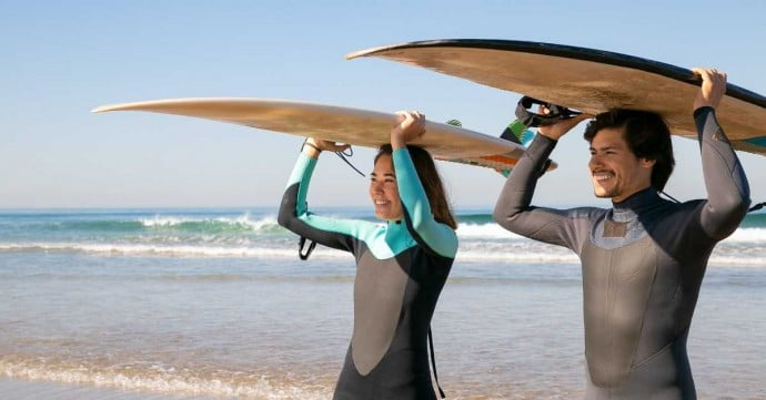 couple going to surf at the beach