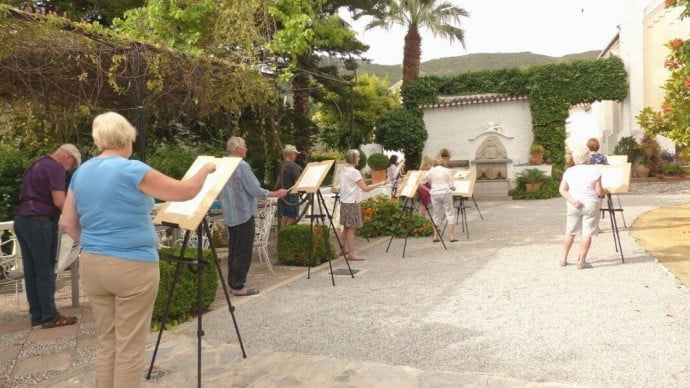 A painting group all painting together out in the sun