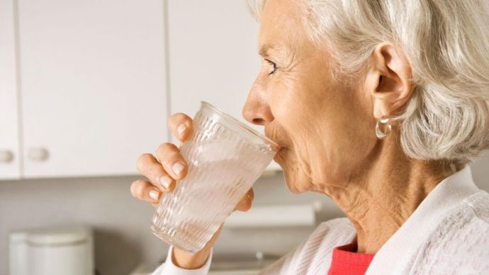 A woman drinking water to keep herself hydrated