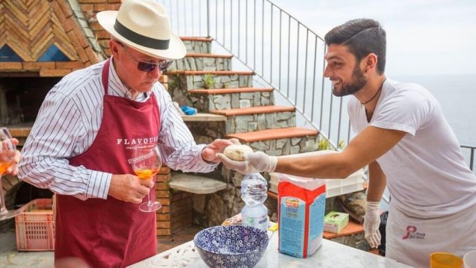 A solo traveller getting taught how to make pizza