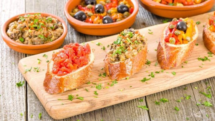 various different types of tapas on wooden board