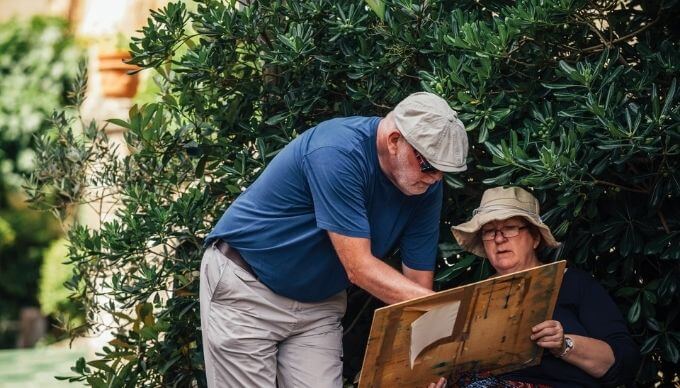 A solo traveller painting with help from her instructor