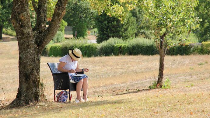 A woman in a peaceful field getting ready to paint