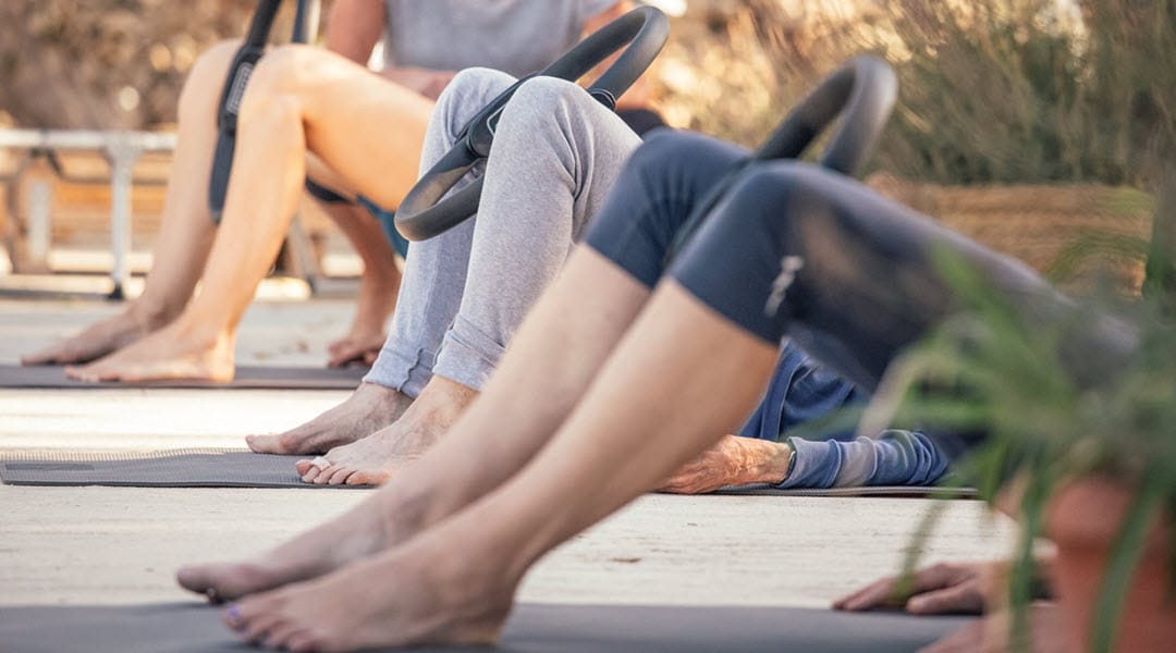 A group of women enjoying a pilates lesson in the sun.