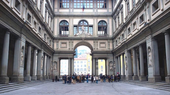 A group of people enjoying the view of the Uffizi Gallery building