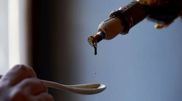 Balsamic vinegar being poured onto a spoon Balsamic vinegar being poured onto a spoon