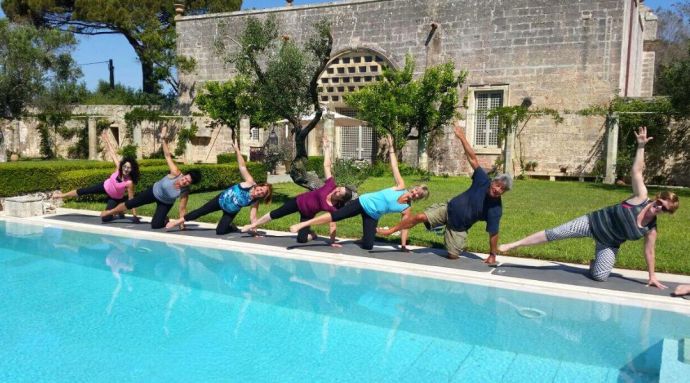 a group of people doing Pilates by a pool