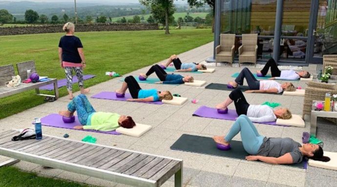 Ladies outdoors lying on their Pilates mat