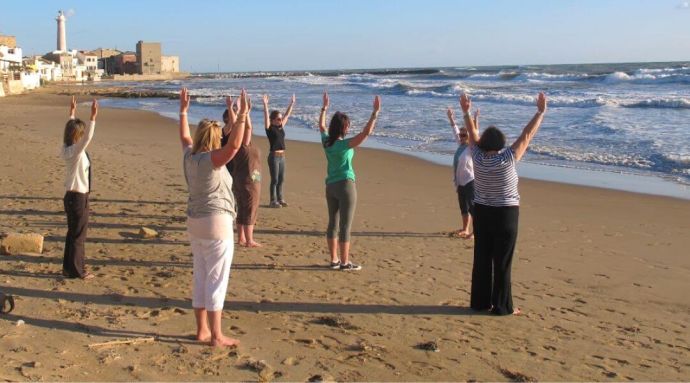 Ladies on the beach doing a Pilates exercise