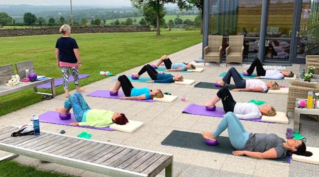 A group Pilates session outdoors