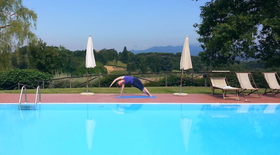 A woman doing a yoga position in beautiful Tuscany