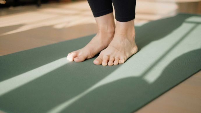 Our favourite wellness podcasts for this year - Feet on a yoga mat ready for class