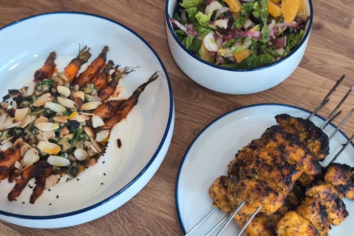 Sticky orange and turmeric chicken skewers, harissa roasted carrots and bitter leaf salad.