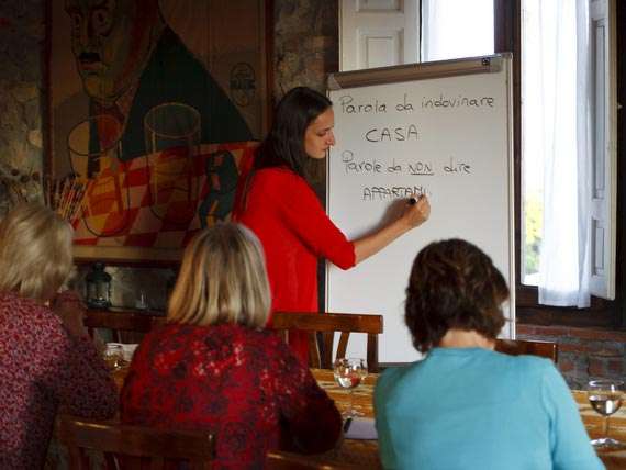 Italian language teacher with group of holiday guests. Italian language teacher with group of holiday guests teaching in local trattoria.