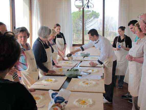 Italian chef showing cooking holiday guests how to make pasta dough. Italian chef showing cookery group how to make pasta dough.